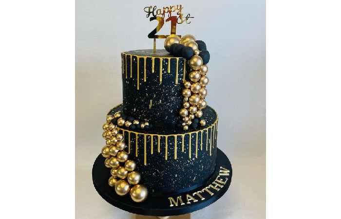 2 tier black and gold theme 21st Birthday cake with drip and contemporary balls decoration and acrylic topper